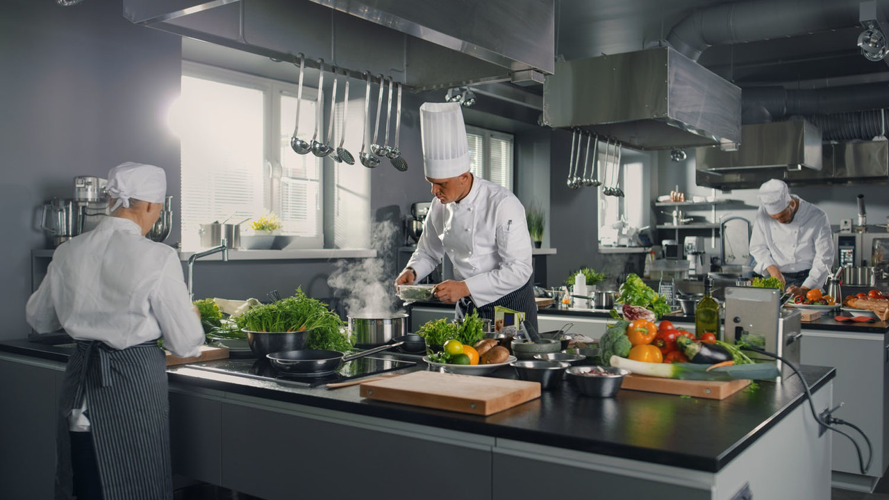 big and glamorous restaurant busy kitchen, chefs and cooks working on their dishes.